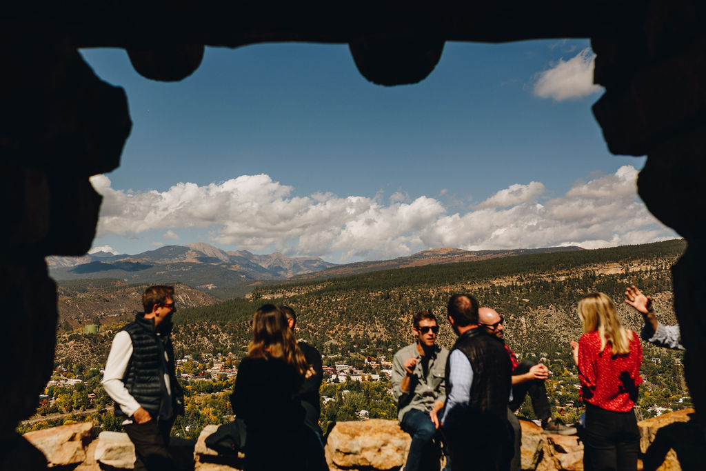 Group gathered at a stone overlook above a rural Colorado mountain town